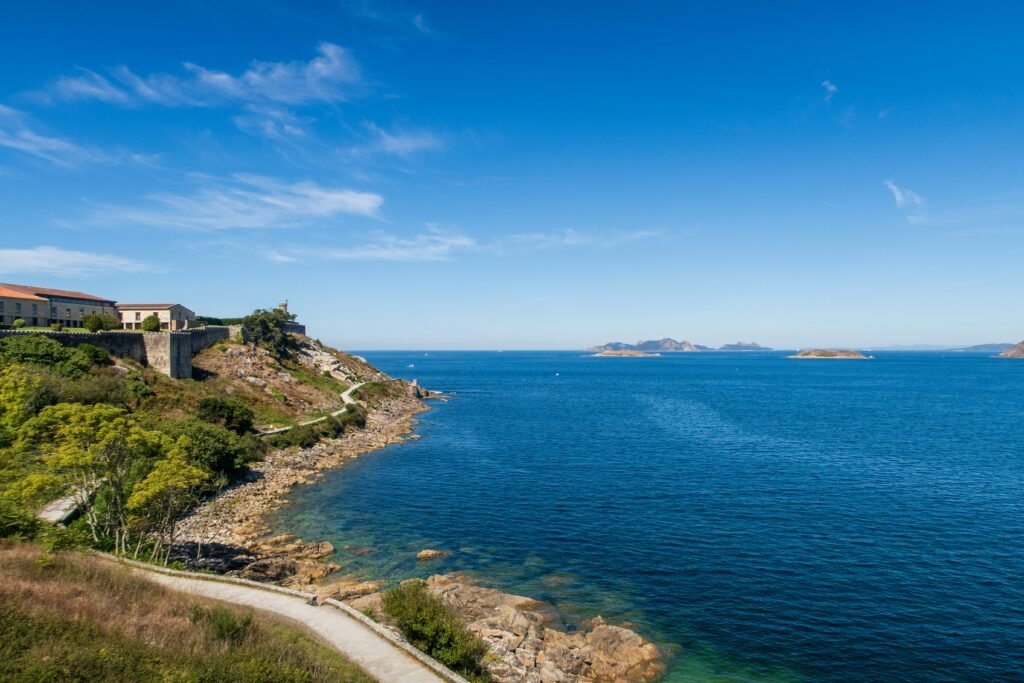 A large body of water sitting next to a lush green hillside